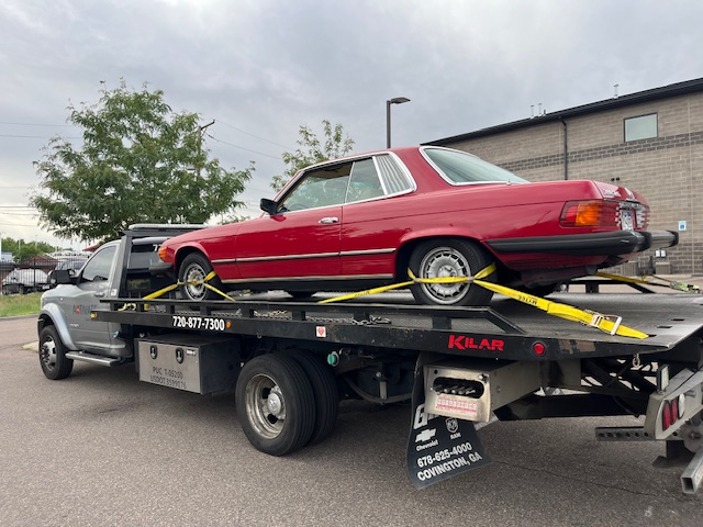 Activate Towing flatbed safely transporting a classic red Mercedes-Benz SLC. Damage-free classic car towing